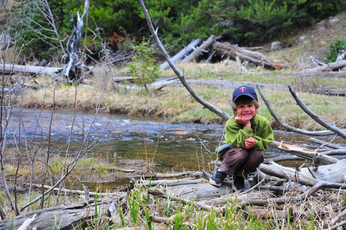 Tory poses on a log on Shingle Creek, Uintas.